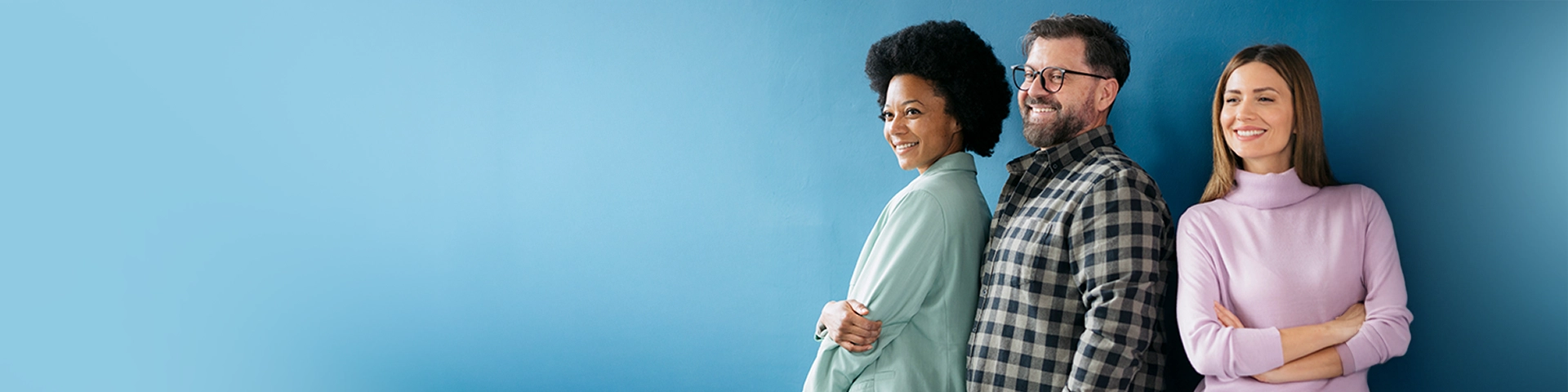 Un gruppo di tre persone  affiancate e sorridenti.