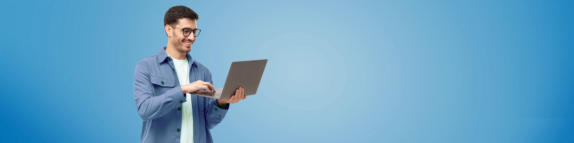 Uomo con una camicia, in piedi con il computer portatile aperto in mano