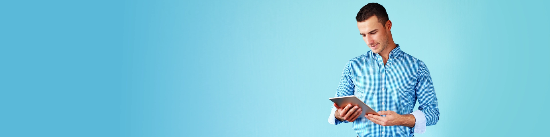 Uomo in camicia a quadri con un tablet in mano su sfondo azzurro