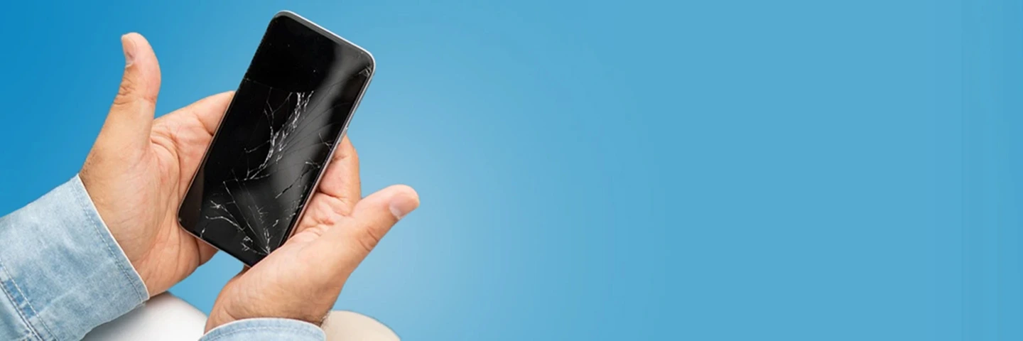 Due mani che tengono uno smartphone  spento con il vetro rotto