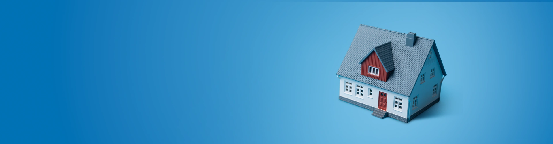 Modellino di casa su sfondo azzurro