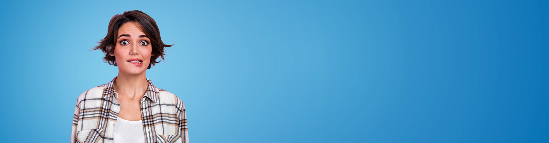 Giovane donna con occhi sgranati che si morde un labbro 