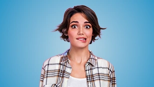 Giovane donna con occhi sgranati che si morde un labbro 