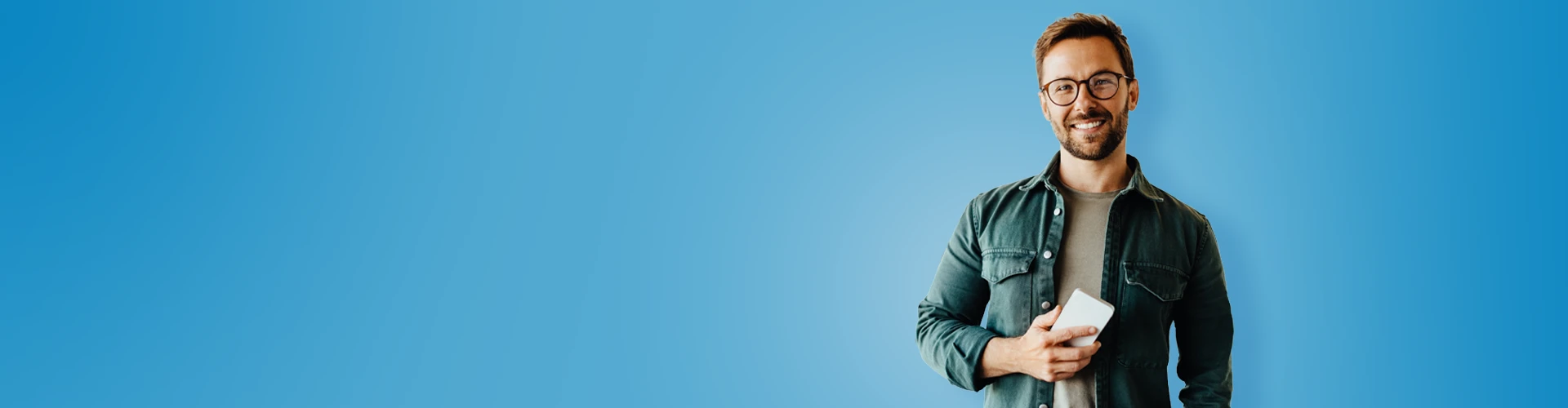 Giovane uomo sorridente con in mano uno smartphone