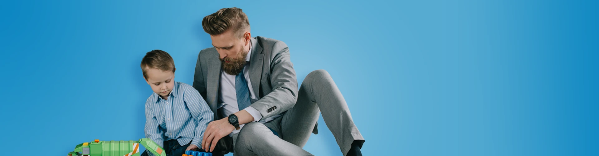 Papà e bambino seduti vicini che giocano