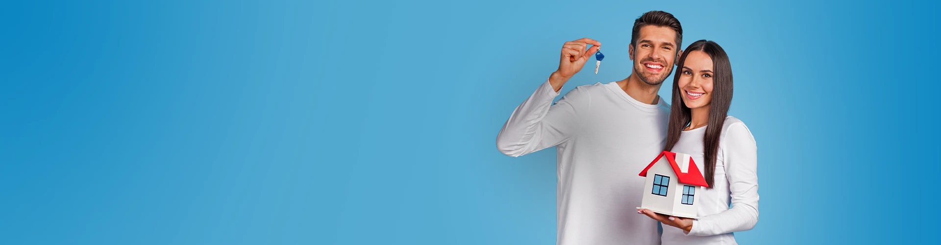 Un uomo e una donna sorridenti con in mano un modellino di casa e un mazzo di chiavi